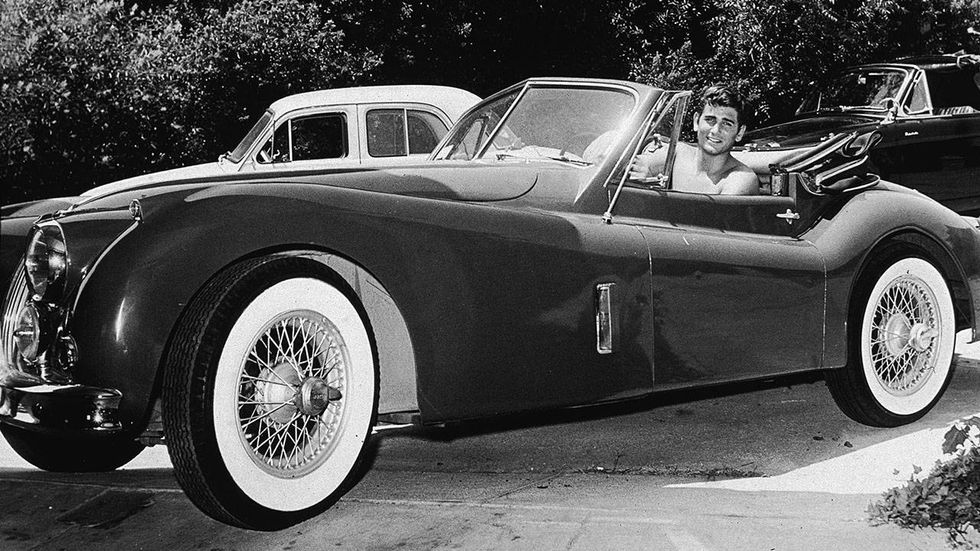 American actor Michael Landon (1936-1991) sits in his Jaguar XK140 and smiles, mid 1950s.