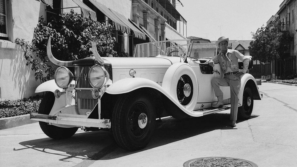 Western star Alan Ladd (1913-1964) poses next to his V16 Cadillac decorated with a large pair of horns, circa 1935.