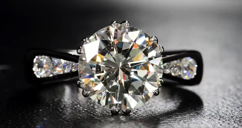 A beautiful round brilliant diamond set in a decorative basket perfectly accented by round brilliants.